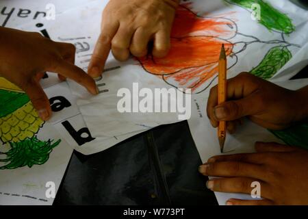 Bogor, West Java, Indonesia - July 2019 : A close up shot of elementary children teaching process using alphabet and drawings in a voluntary class. Stock Photo