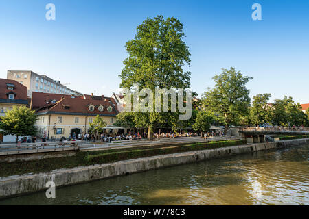 Ljubljana, Slovenia. August 3, 2019. the sight of people in outdoor cafes along the shore  of the river Ljubljanica in the city center Stock Photo