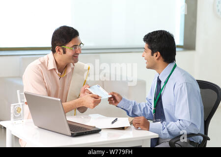 Bank manager giving cheque to his customer as loan Stock Photo
