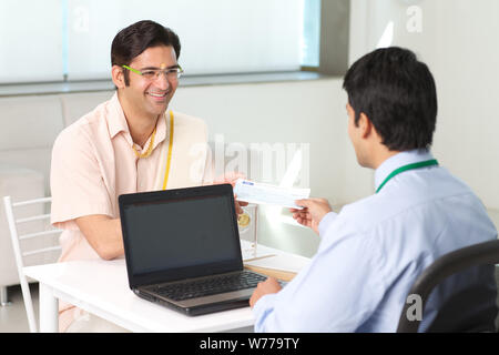 Bank manager giving cheque to his customer as loan Stock Photo