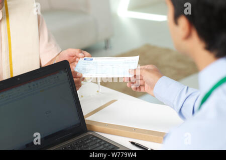 Bank manager giving cheque to his customer as loan Stock Photo