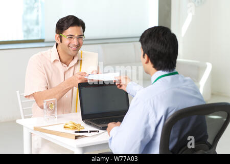 Bank manager giving cheque to his customer as loan Stock Photo