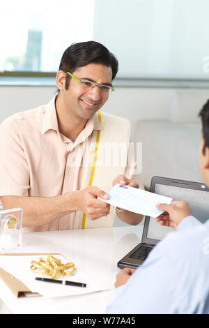 Bank manager giving cheque to his customer as loan Stock Photo
