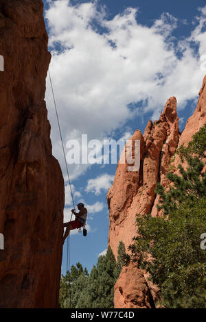 A  rock climber tests a wall in the Garden of the Gods, a public park, but also an international tourist attraction, packed with red-rock formations in Colorado Springs, Colorado Physical description: 1 photograph : digital, tiff file, color.  Notes: Purchase; Carol M. Highsmith Photography, Inc.; 2015; (DLC/PP-2015:068).; Forms part of: Gates Frontiers Fund Colorado Collection within the Carol M. Highsmith Archive.; Created during a geological upheaval along a natural fault line millions of years ago, the area was first called Red Rock Corral. Then, in August 1859, two surveyors who helped to Stock Photo