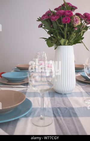 Decoration flower bouquet and empty wineglasses on an empty dining table Stock Photo