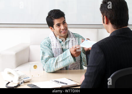 Bank manager giving cheque to his customer as loan Stock Photo