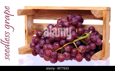 fresh red grapes falling out standing crate isolated on white Stock Photo