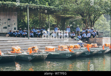 Ninh Binh, Vietnam - May 2019: boatmen waiting for boat tour clients in Trang An nature park. Stock Photo