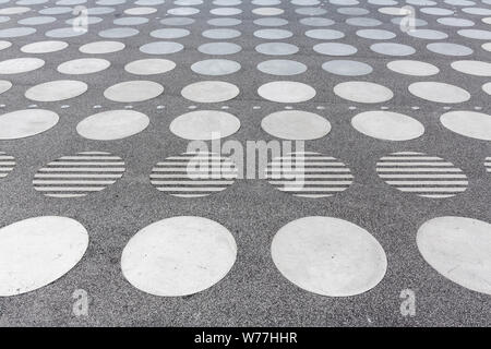 A concrete square with a symmetrical white circle pattern seen in perspective. Stock Photo