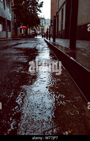 Rainy urban scene with water drops falling on a wet floor Stock Photo