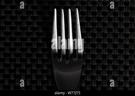 Bright silver grey fork cutlery on a pattern grey background Stock Photo