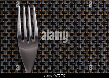Bright silver grey fork cutlery on a pattern grey background Stock Photo