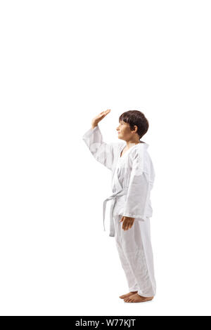 Full length profile shot of a boy in karate kimono gesturing high-five with hand isolated on white background Stock Photo