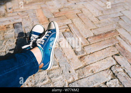 Foot and legs seen from above on a brick, rustic background. Selfie of sneakers on the floor great for any use. Stock Photo