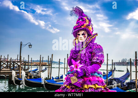 Venice, Italy, Carnival of Venice, beautiful mask at Piazza San Marco with gondolas and Grand Canal. Stock Photo