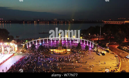 (190805) -- HARBIN, Aug. 5, 2019 (Xinhua) -- Tourists are seen at the square of memorial tower for flood control in Harbin, capital of northeast China's Heilongjiang Province, July 30, 2019. Attracted by the coolness in summer, many tourists come to Harbin for vacation. Meanwhile, Harbin is a city of music for the locals who got in touch with European classical music in an earlier time in China. With the cool summer and rich culture, Harbin received 36.23 million tourists and made revenue of 60.7 billion yuan (8.6 billion U.S. dollars) in the summer of 2018. (Xinhua/Wang Jianwei) Stock Photo