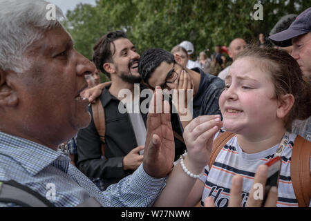 A 12-year-old heckler (R) takes on a religious speaker. Preaching, debates and sermons at Speakers’ Corner, the public speaking corner of Hyde Park. Stock Photo