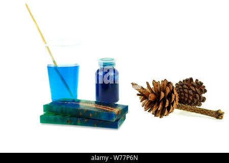Casting pine cone hybrid and mixing color epoxy resin in plastic cup at white background Stock Photo