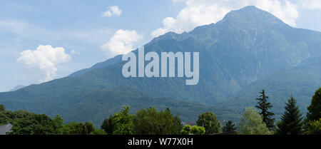 Fantastic view of mountains and trees on a sunny summer day. District of Como Lake, Colico, Italy, Europe. Panoramic view.