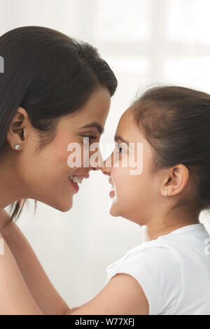 Woman and her daughter rubbing their noses together Stock Photo