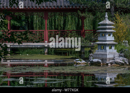 Pagoda garden statue at a lake with reflections in the water Stock Photo