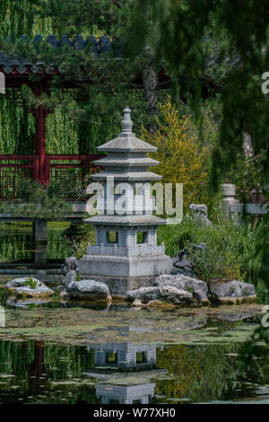 Pagoda garden statue at a lake with reflections in the water Stock Photo
