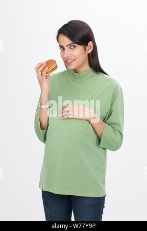 Pregnant woman eating burger