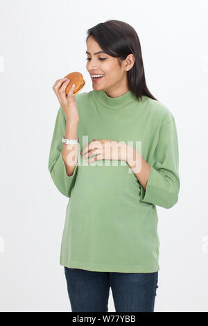 Pregnant woman eating burger