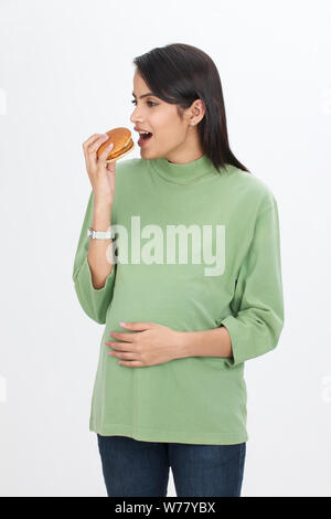 Pregnant woman eating burger