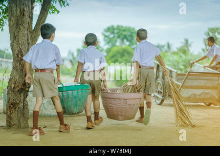 Male Students help to remove rubbish from the classroom to pile waste Stock Photo