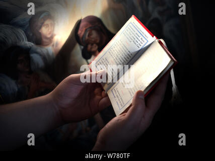 Young man in reading prayer book Stock Photo