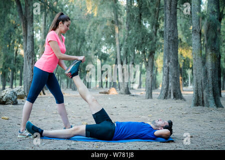 Caucasian couple doing stretching exercises in a park Stock Photo