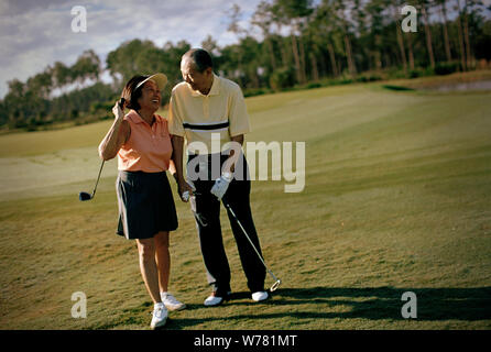 Mature couple having fun while playing golf together. Stock Photo
