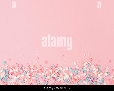 Festive border frame of colorful pastel sprinkles on pink background, copy  space top. Sugar sprinkle dots and stars, decoration for cake and bakery.  Top view or flat lay Stock Photo - Alamy