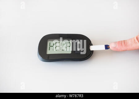 Glucometer asks for help after measuring the blood sugar: concept of hyperglycemia Stock Photo