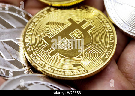 Golden Bitcoin in a man hand, Digitall symbol of a new virtual currency Stock Photo