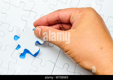 Person fitting the last puzzle piece.Concept image of building and button up Stock Photo