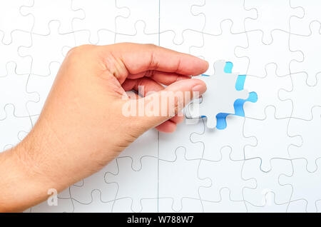 Person fitting the last puzzle piece.Concept image of building and button up Stock Photo