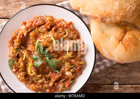 Baingan bharta (mashed eggplant) is a dish from the Indian that originated in the Punjab region closeup on the plate on the table. horizontal top view Stock Photo