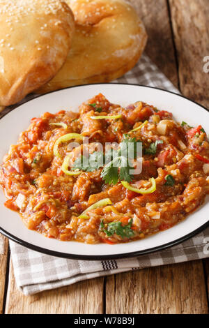 Baingan bharta (mashed eggplant) is a dish from the Indian that originated in the Punjab region closeup on the plate on the table. Vertical Stock Photo