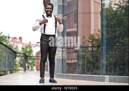 Handsome fashionable african american man in formal wear, bow tie and  suspenders, walking stick Stock Photo - Alamy