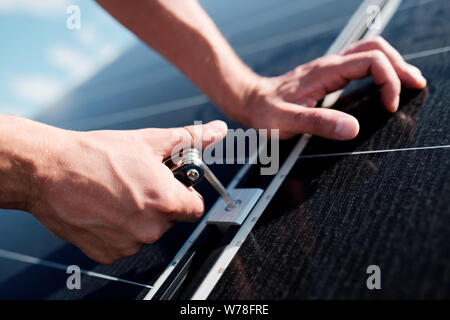 Hands of professional technician or engineer installing solar panels Stock Photo