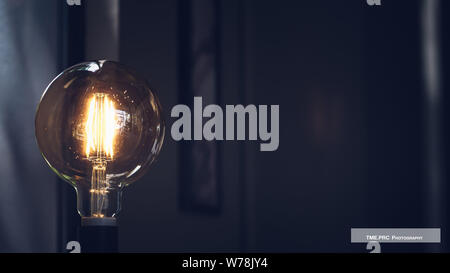 Glowing yellow light bulb, Realistic photo image turn on tungsten light bulb. Energy and idea symbol. Decoration for greeting cards, patches, prints f Stock Photo