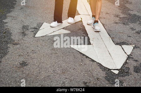 People standing at the crossroad and get to decision which way to go with copy space for insert text. Two ways to choose concept. Stock Photo