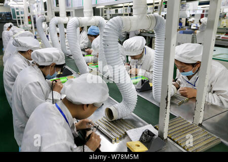 --FILE--Female Chinese workers produce mobile phone parts on the assembly line at a factory in Huaibei city, east China's Anhui province, 7 March 2017 Stock Photo