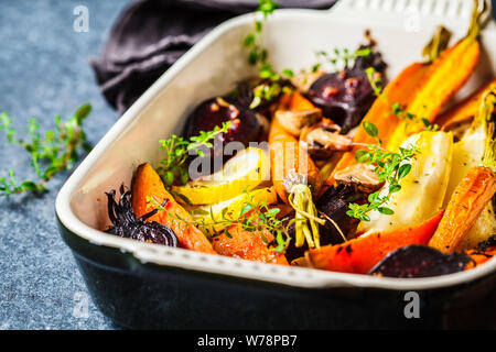 Baked carrots, sweet potatoes, beets and zucchini in oven dish. Stock Photo