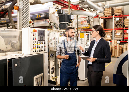Two young business partners discussing working methods of industrial production Stock Photo