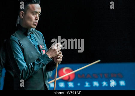 Marco Fu of Hong Kong chalks his cue as he considers a shot to Robert Milkins of England in their second round match during the 2017 Shanghai Masters Stock Photo