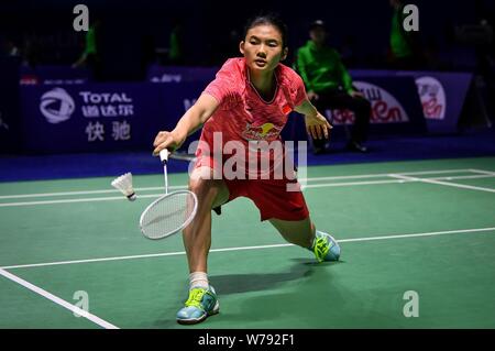 Han Yue of China returns a shot to Sayaka Takahashi of Japan during the
