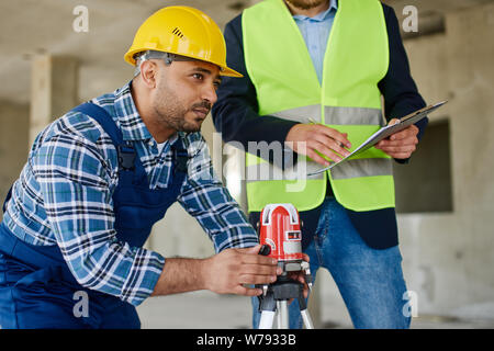 Two engineers on the construction use working equipment. Stock Photo